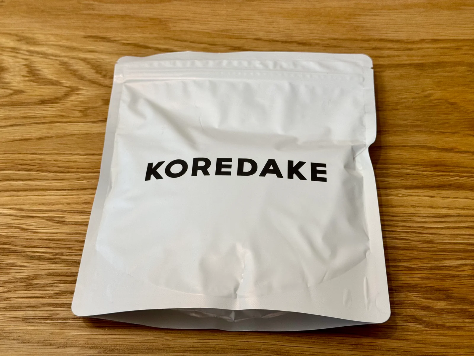 木のテーブルに置いたKOREDAKEのパッケージ